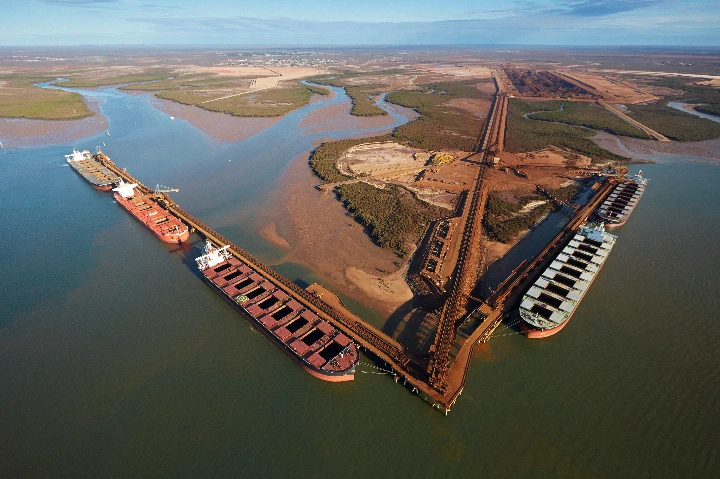 China, BHP and the Iron Ore Standoff: Who Really Takes the Hit?

Imagine the world’s busiest iron ore port, with hundreds of ships lining up each year, waiting to haul Australia’s fortune away. That’s Port Hedland in Western Australia, the beating heart of the global iron ore trade.

From BHP’s massive Pilbara mines, trains stretch almost 400 kilometres to reach the coast. Day and night, they tip their cargo into waiting carriers bound for steel mills around the world. The largest share? China — by far Australia’s biggest customer.

But this week, the trade hit a bump. Reports out of Beijing suggest China’s state iron ore buyer has told steel mills to pause purchases from BHP. Analysts describe it as a negotiating tactic — a way for Beijing to apply pressure during tense price talks.

The stakes are enormous. Billions of dollars flow through these trains and ships every year. Iron ore is not just another export; it underpins Australia’s economy and helps drive China’s construction boom.

Could China really cut BHP off for long? Probably not. Alternatives like Rio Tinto, Fortescue, Brazil’s Vale, or even domestic Chinese ores exist — but none can fully replace BHP’s scale and efficiency. At the same time, BHP depends heavily on the Chinese market, meaning both sides have something to lose.

That’s why most observers see this less as a “ban” and more as brinkmanship. Beijing wants cheaper long-term prices. BHP wants fair value for its ore. The result? Headlines that shake markets, and a share price wobble that reflects investor nerves.

In the end, China can’t build its modern economy without Australian iron ore, and Australia can’t ignore its largest trading partner. The question is: in a high-stakes game of chicken over price, who blinks first — and who really takes the hit?